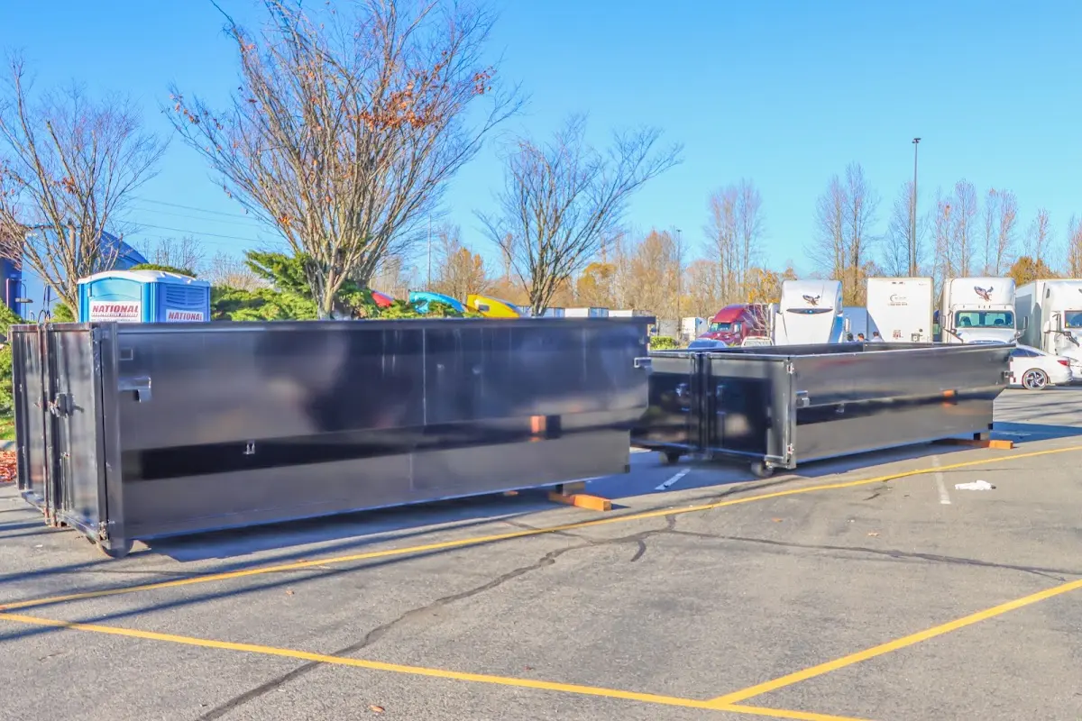 Professional dumpster rental service with roll-off container on residential driveway in Le Mars